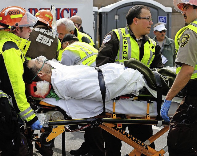 Ein Schwerverletzter wird von Rettungs... den Boston-Marathon abtransportiert.   | Foto: AFP