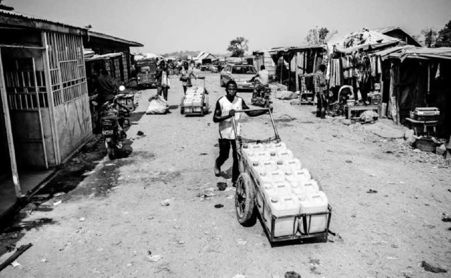 Wasserverkufer in einem Slum der Hauptstadt Abuja   | Foto: Andy Spyra