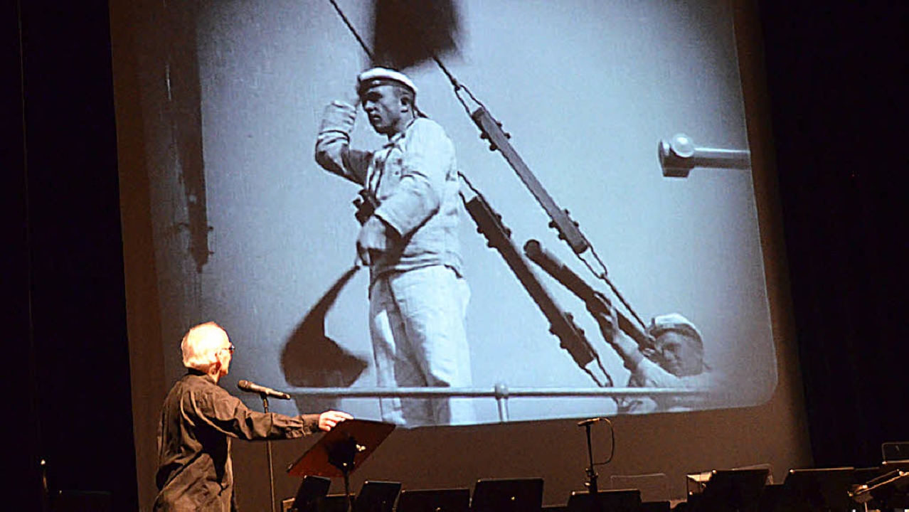 Dirigent David LeClair vor einer Filmszene.   | Foto: Adrian Steineck