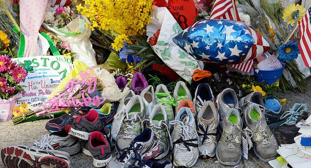 Mit  Blumen, US-Flaggen und Turnschuhe...die Bostoner der Opfer des Marathons.   | Foto: AFP