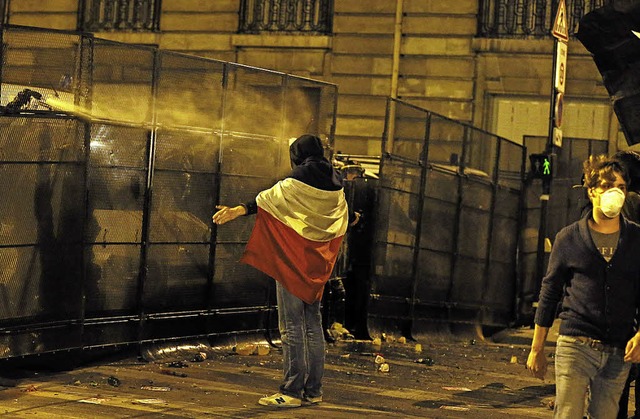 Ein Demonstrant hllt sich in Paris in die Nationalfahne.   | Foto: AFP