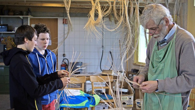 Michael Bubenzer zeigt Semjon Mller u...n rechts) die Kunst des Korbflechtens.  | Foto: Christian John