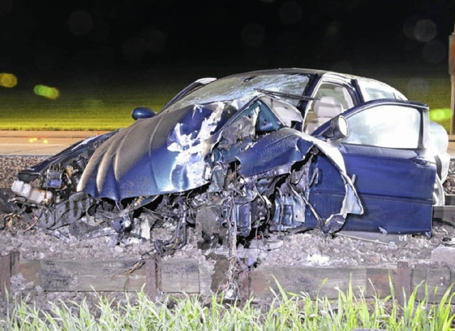 Das komplett zerstrte Auto auf den Bahngleisen   | Foto: Polizei BL