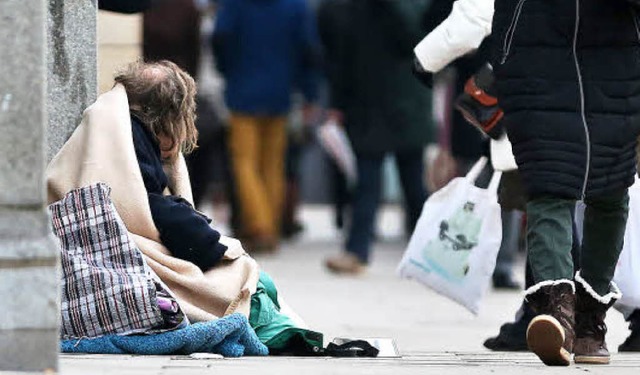 Ein Mann sitzt  in der Innenstadt von Hamburg und bittet um eine Spende.   | Foto: dpa