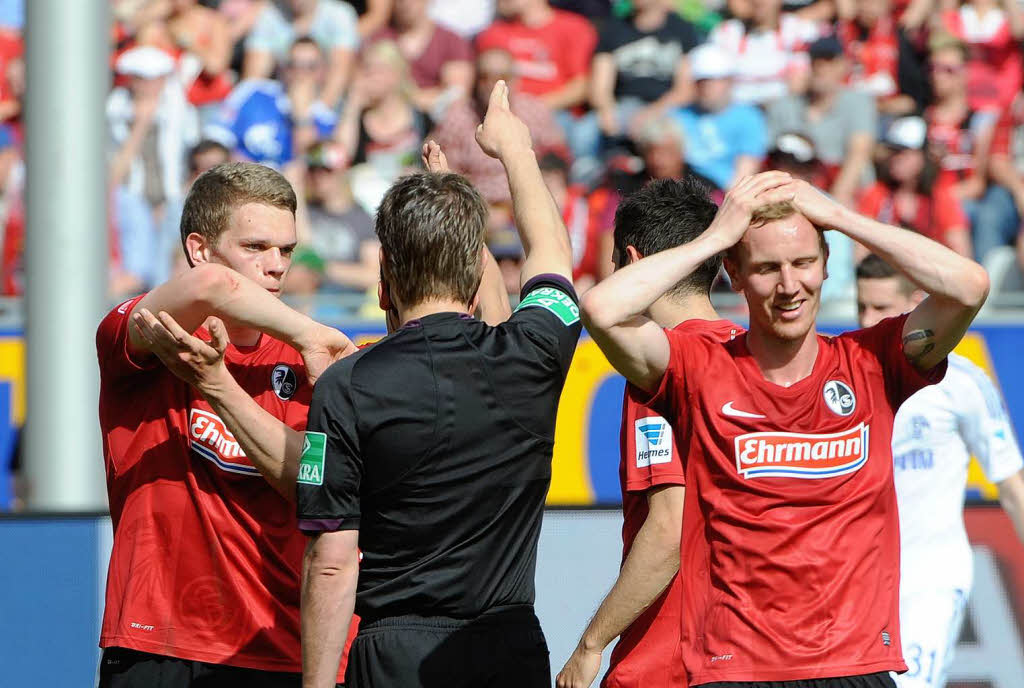 Matthias Ginter (links) moniert, dass ein Schalker den Ball mit dem Ellenbogen abgewehrt haben soll. Der Schiedsrichter sieht das anders.