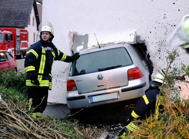 Skurriler Anblick: Der Golf steckt mit...e Feuerwehr den Unfallort begutachtet.  | Foto: WOLFGANG KUENSTLE               