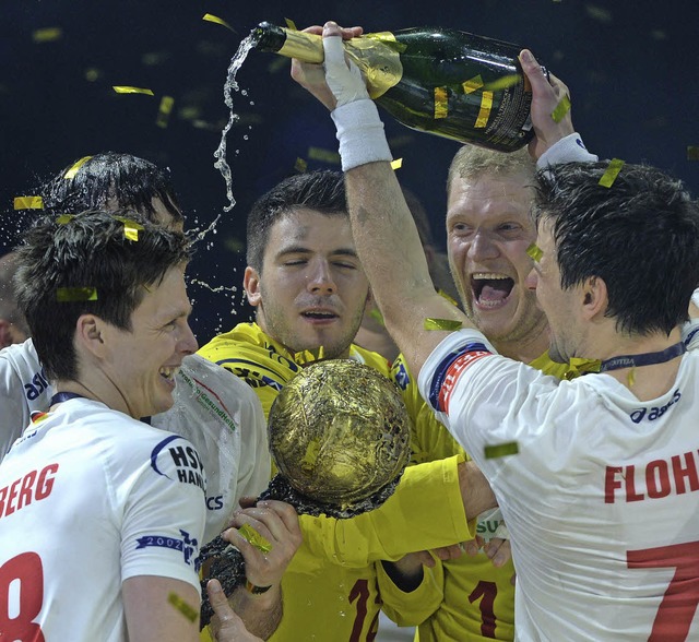 Die Hamburger Spieler freuen sich mit einem edlen Getrnk und dem Pokal.   | Foto: Afp