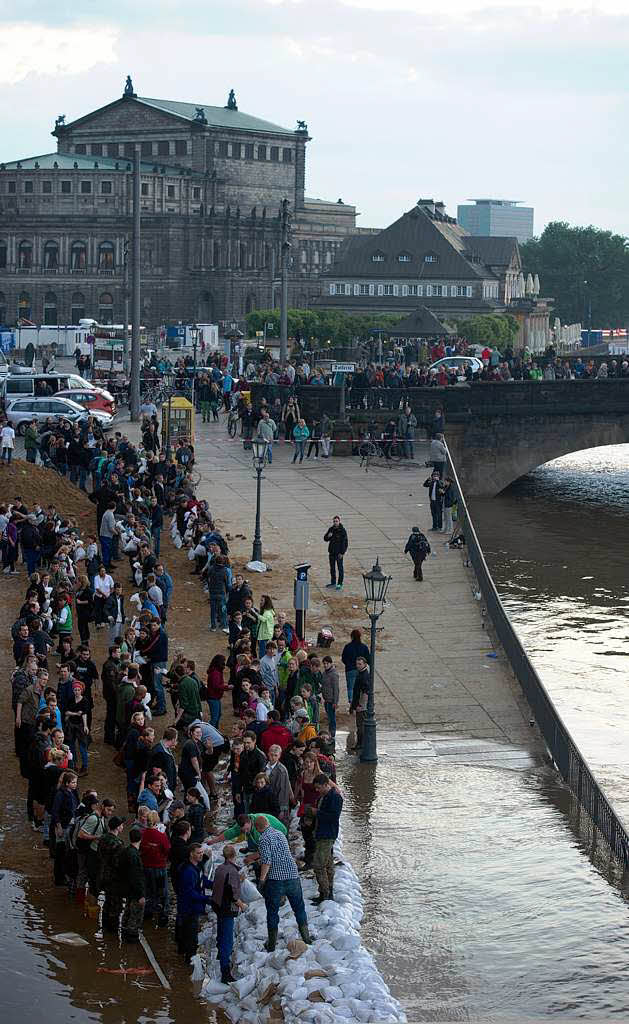 Freiwillige Helfer arbeiten am Terrassenufer in Dresden gegen das Hochwasser der Elbe an.