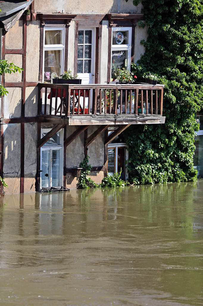 Huser stehen im Hochwasser der Saale in Halle.