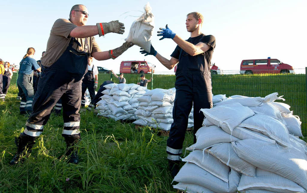 Freiwillige Helfer der Feuerwehr verpacken  nahe der Ortschaft Stiepelse im Amt Neuhaus (Niedersachsen) Sandscke. Entlang der Elbe droht Niedersachsen zum Wochenende ein krftiger Anstieg des Hochwassers.