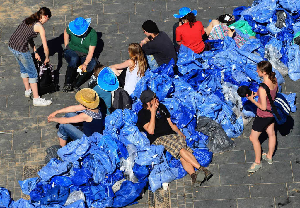 Freiwillige Helfer ruhen sich auf dem Marktplatz in Halle/Saale (Sachsen-Anhalt) beim Befllen von Sandscke aus.