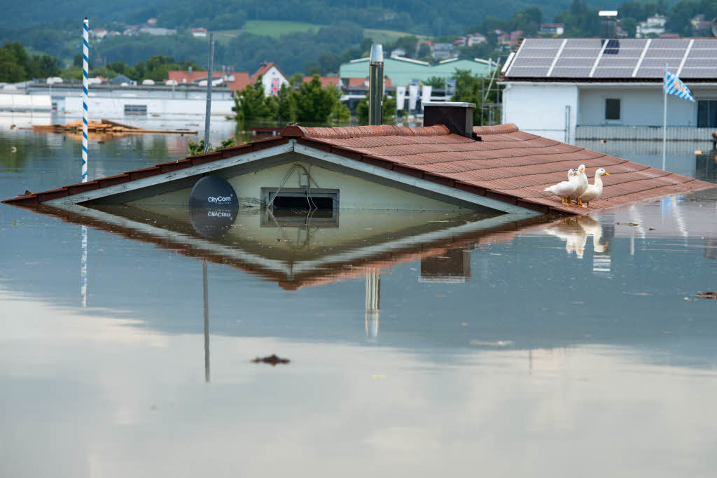 Nur doch das Dach von einem Wohnhaus ragt im Deggendorfer Ortsteil Fischerdorf (Bayern) aus dem Hochwasser der Donau.