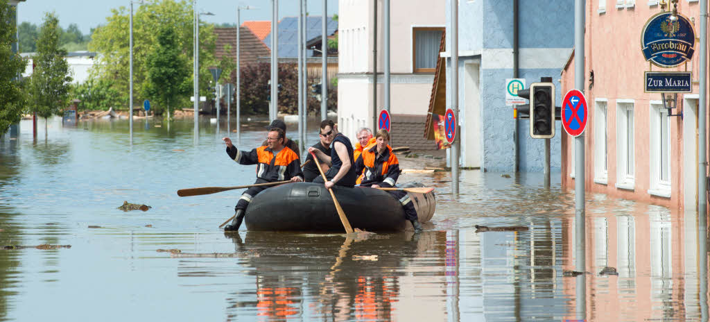 Rettungskrfte fahren im Deggendorfer Ortsteil Fischerdorf (Bayern) mit einem Schlauchboot durch das Hochwasser der Donau.