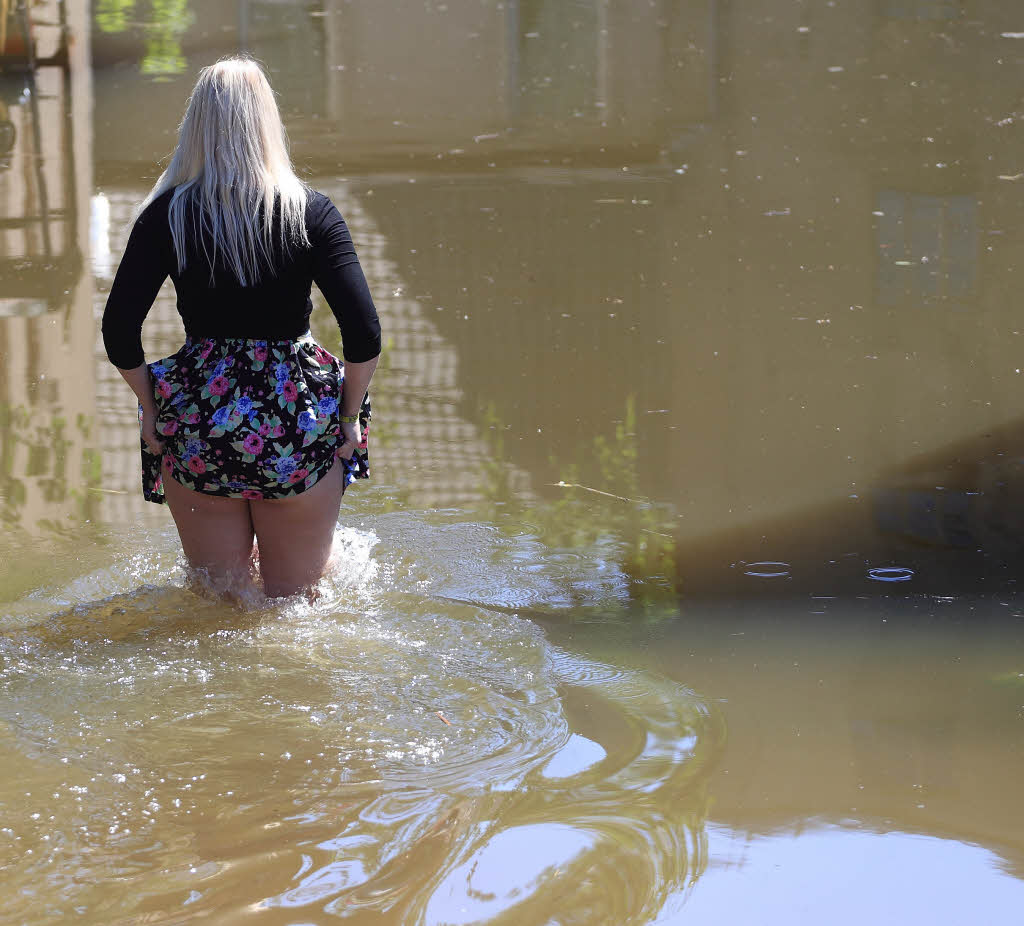 Eine Frau watet durch ein vom Hochwasser der Bode berflutetes Grundstck in Nienburg (Sachsen-Anhalt), um private Dinge zu holen. In der Stadt mndet die Bode in die Saale.