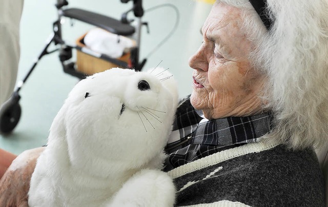 Eine demenzkranke  Frau hlt einen Pl...zu erreichen, die unter Demenz leiden.  | Foto: dpa