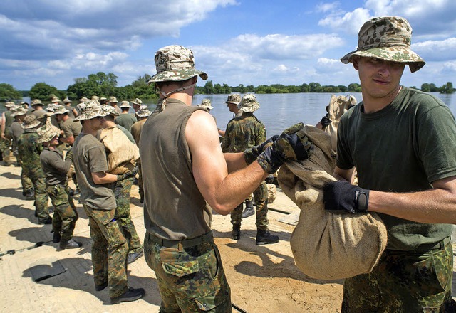 Soldaten bringen mit einer Faltschwimmbrcke Sandscke  | Foto: DPA