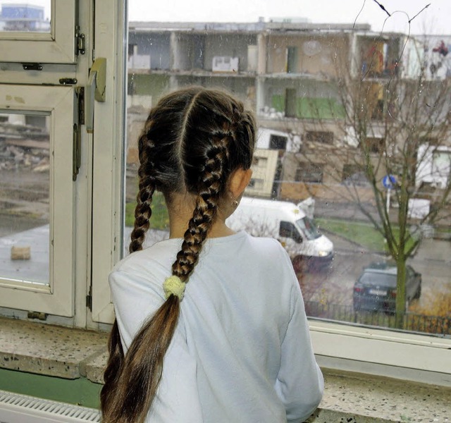 Ein Mdchen schaut aus dem Fenster nac...jekt Die Arche in Berlin-Hellersdorf.   | Foto: dpa