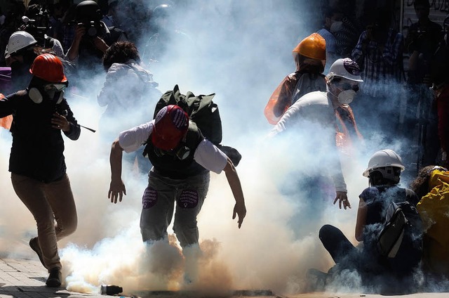 Demonstranten versuchen, vor dem Trnengas der Polizisten davonzulaufen.   | Foto: dpa