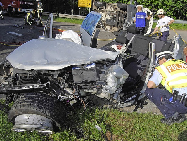 Ein Polizist begutachtet das vllig de...r den verletzten Fahrer befreit hatte.  | Foto: Kamera24