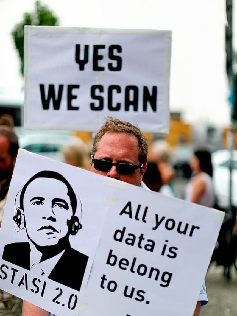 Mit Plakaten demonstrieren Menschen gestern, 18. Juni, am Checkpoint Charlie in Berlin gegen das US-amerikanische Internetberwachungsprogramm der NSA Prism.