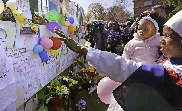 Blumen und Gebete hngen am Zaun vor d...Pretoria, wo Mandela im Sterben liegt.  | Foto: dpa