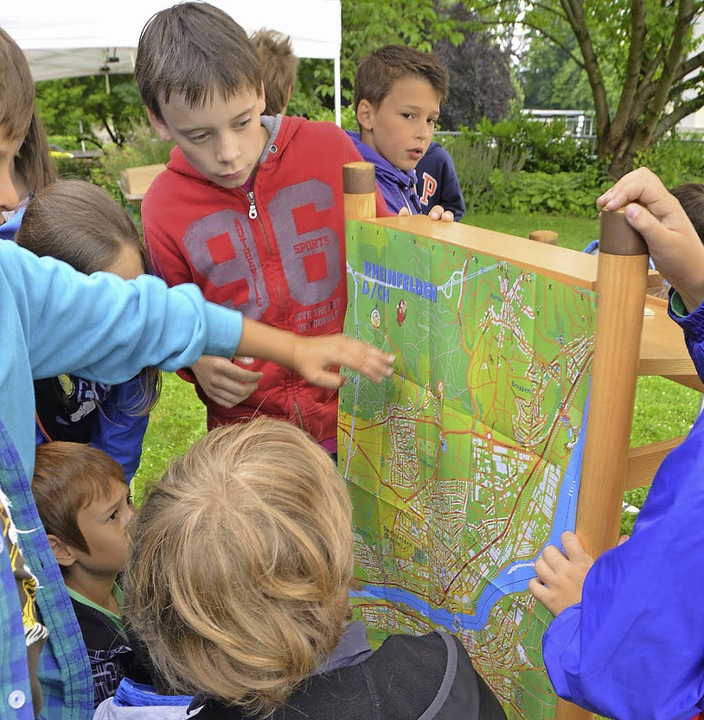 Kinder betrachten neugierig den Stadtplan.  | Foto: Peter Gerigk