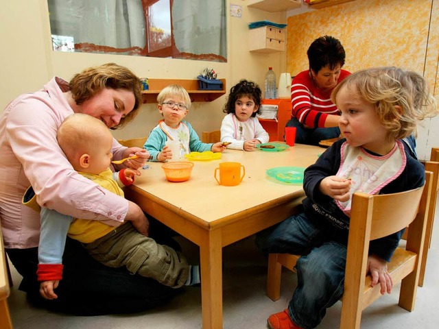 Erzieherinnen fttern  in der Kinderkr...;Zwergenland&#8220; in Staufen Kinder.  | Foto: dpa