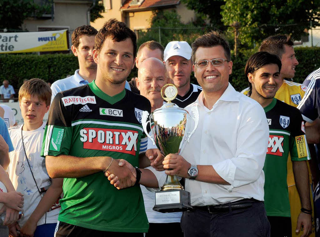 Markus Weiss (Brauerei Frstenberg, r.) berreicht den Pokal an Guillaume Katz vom Siegerteam Lausanne.