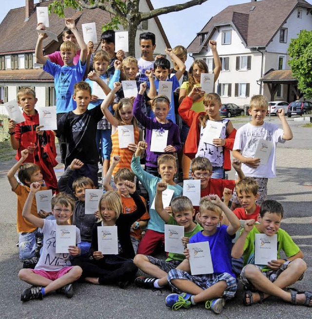 Strahlende Kinder prsentieren stolz ihre Urkunden.   | Foto: Trndle