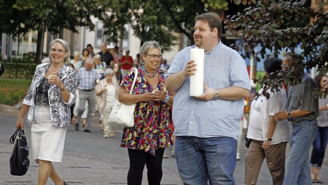 Mit der Kerze vorneweg: Pfarrer Steffe...erprozession zur katholischen Kirche.   | Foto: h. fssel