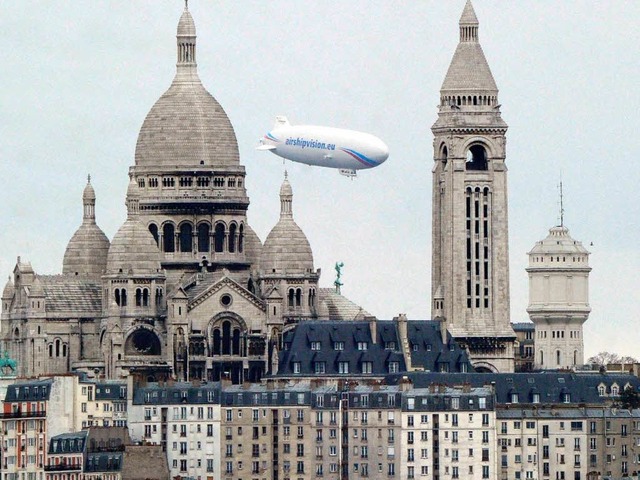 Ein Zeppelin der Firma Airship schwebt...orischen Kirche  Sacr-Coeur in Paris.  | Foto: AFP