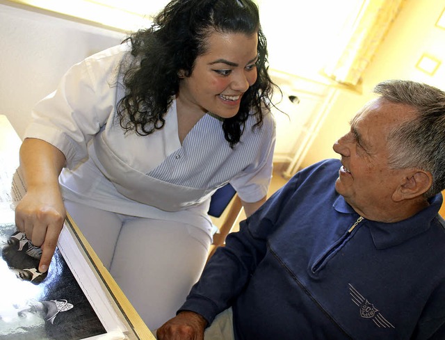 Glendem Emre schaut mit einem Patienten Fotos von frher an.   | Foto: Eva-Maria Klassen
