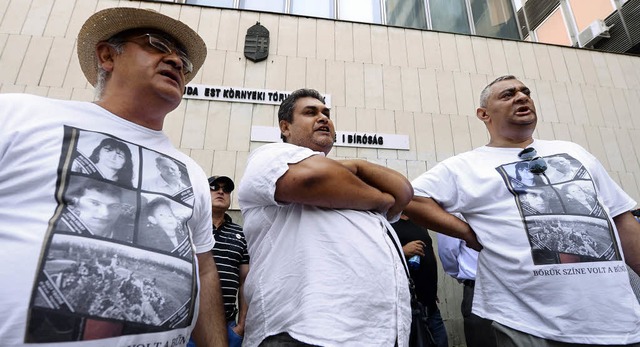 Roma-Aktivisten tragen Shirts mit Foto...rdserie vor dem Gericht  in Budapest.   | Foto: dpa