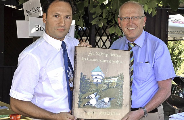 Christian Schejka (links) bekommt von ... mit dem Wahrzeichen, dem Taubenturm.   | Foto: Martina Proprenter