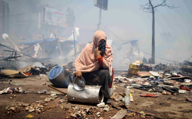 Eine Frau hockt in einem  gerumten Protestcamp der Muslimbrder in Kairo.   | Foto: dpa