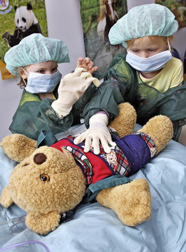Zwei Mdchen untersuchen einen Teddy.   | Foto: dpa