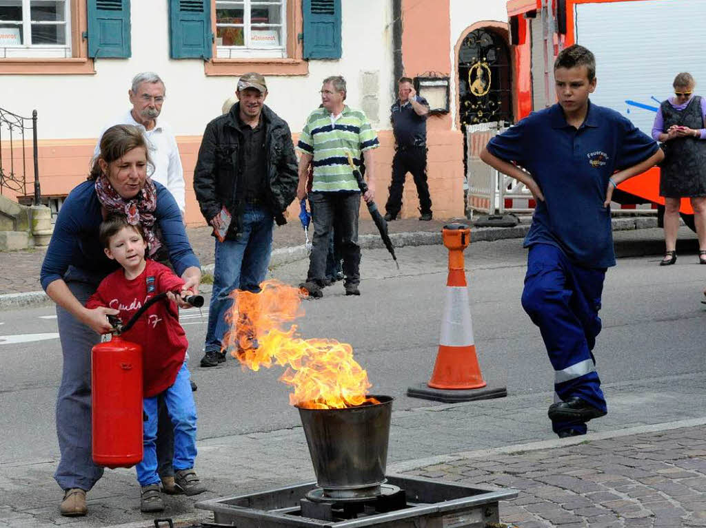 Kinder probieren das das Lschen eines Feuers mit dem Feuerlscher aus.