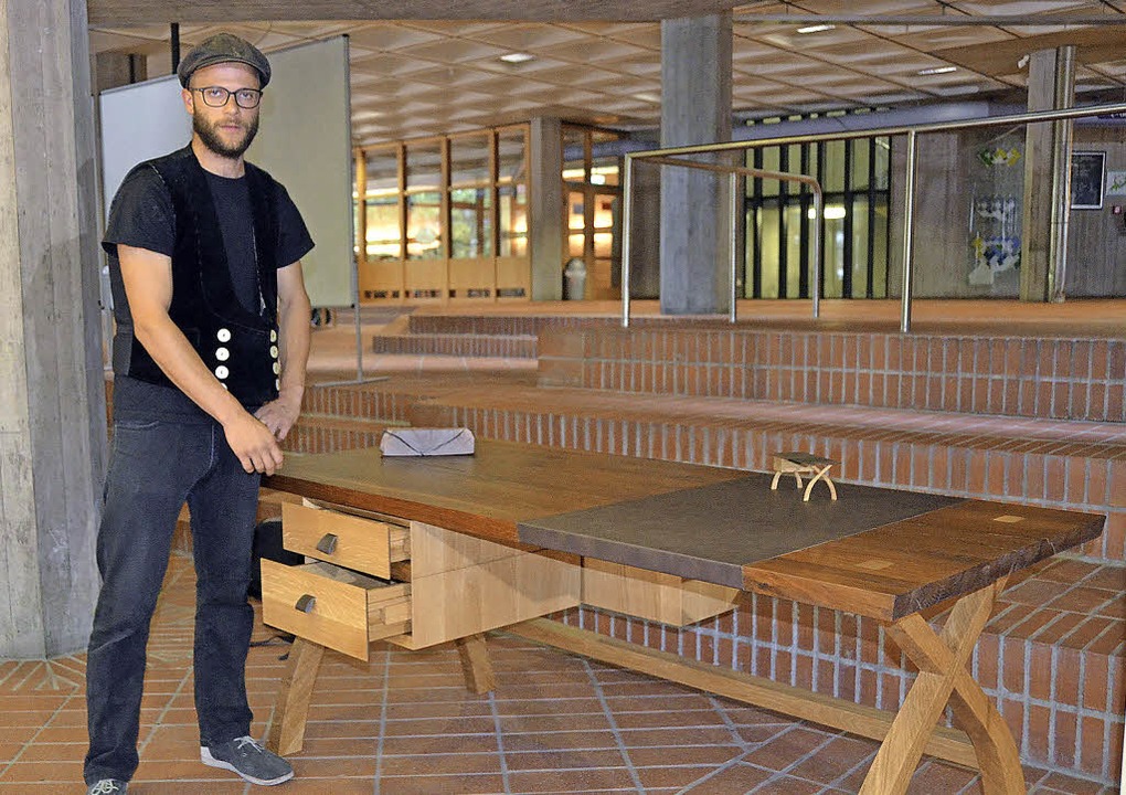 Schreibtisch mit Altholz: Janaka Siedel stellt sein Prüfungsprojekt vor.   | Foto: Julia Juran
