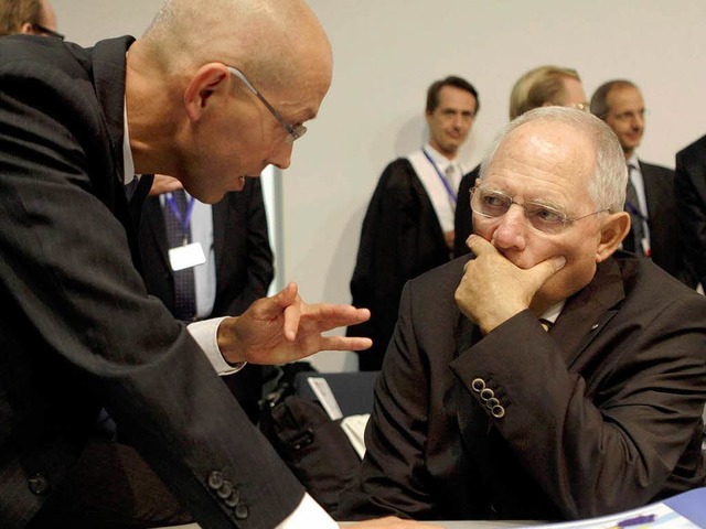 Der Deutsche Jrg Asmussen (l.) von de...er Wolfgang Schuble dagegen bremst.    | Foto: dpa