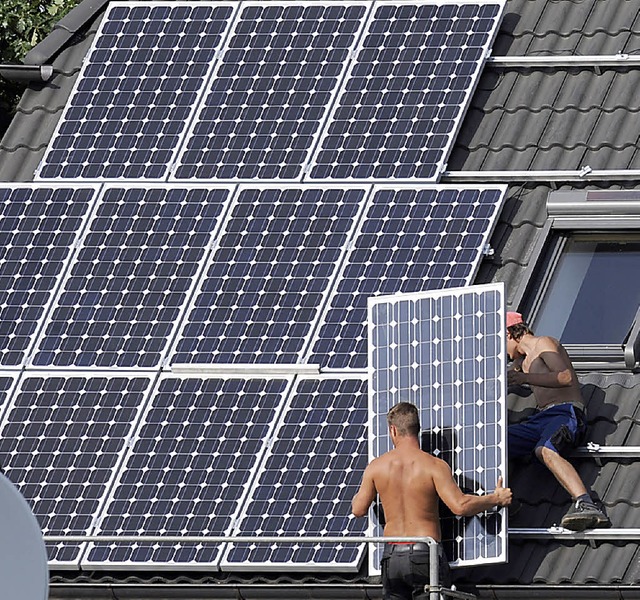 Auf ein Einfamilienhaus wird eine Photovoltaikanlage installiert.   | Foto: dpa