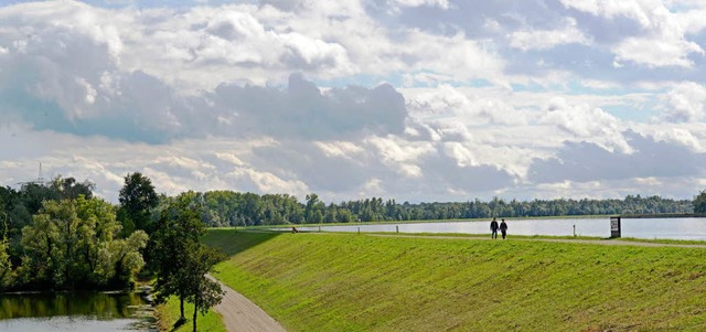 Ein Paar flaniert ber den Rheindamm b...von ihnen ein Rckhalteraum entstehen.  | Foto: dpa