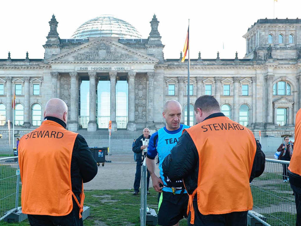 Sicherheitspersonal kontrolliert die Teilnehmer im Start- und Zielbereich am Berliner Reichstag.