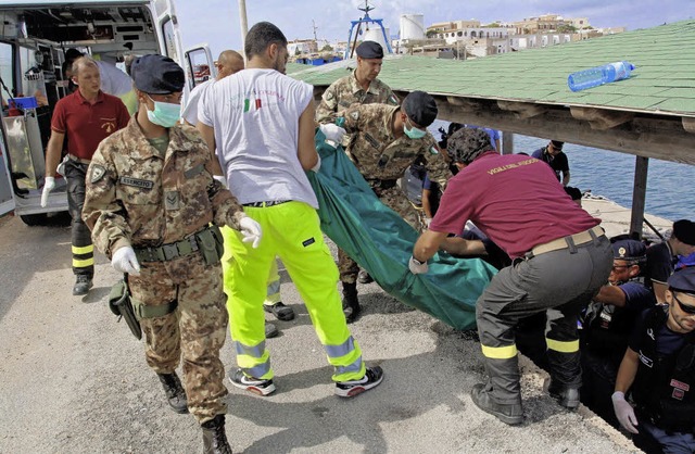 Angehrige der italienischen Kstenwac...rgen Opfer des Unglcks vor Lampedusa.  | Foto: dpa