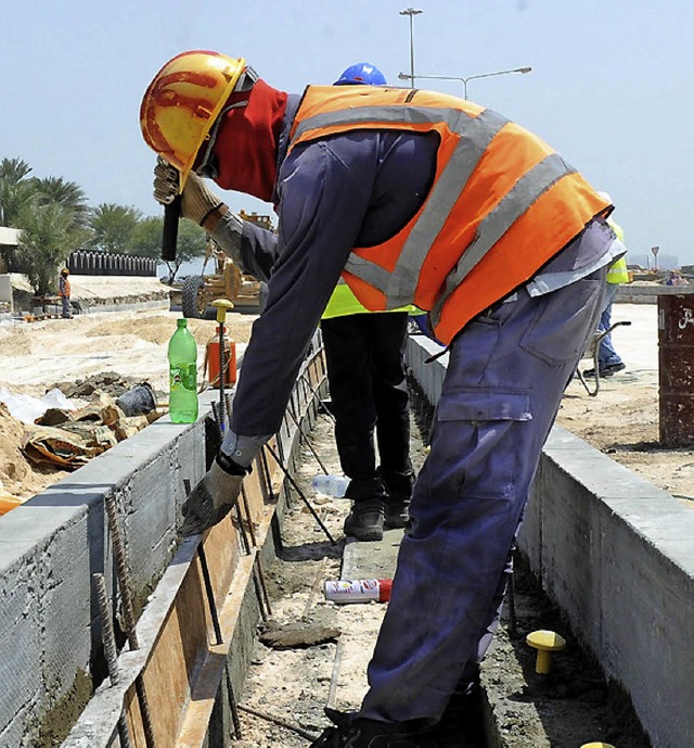 Kampf gegen Staub, Durst, Bakterien: Bauarbeiter in Katar   | Foto: dpa