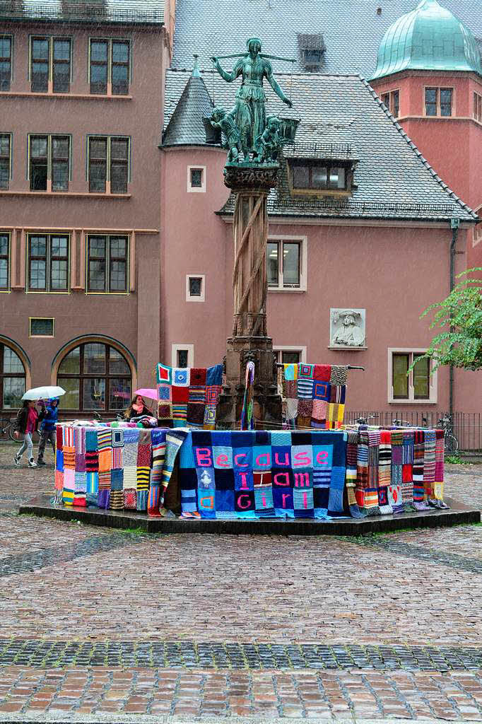 Viele Quadrate ergeben eine kuschlig-bunte Strickdecke fr den Brunnen auf dem Kartoffelmarkt in Freiburg.