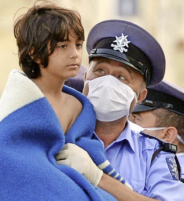 Ein maltesischer Polizist hlt ein gerettetes Flchtlingskind.  | Foto: AFP