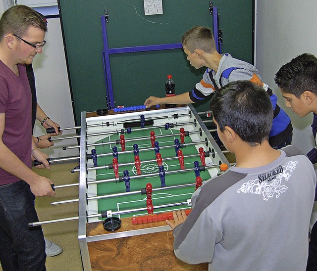 Sven van der Gabel spielt mit den Jugendlichen am Neuerffnungstag Tischkicker.   | Foto: Heinz Vollmar