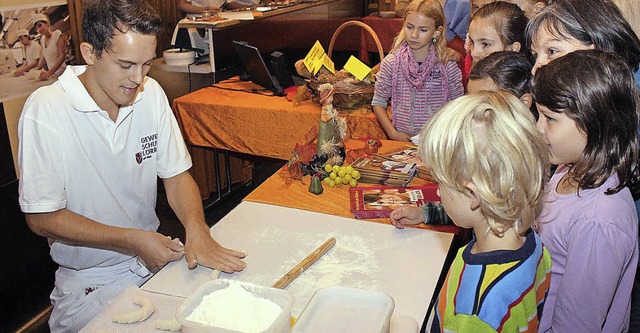 Ein Bcker-Azubi zeigt Kindern, wie Gebck geformt wird.   | Foto: zvg