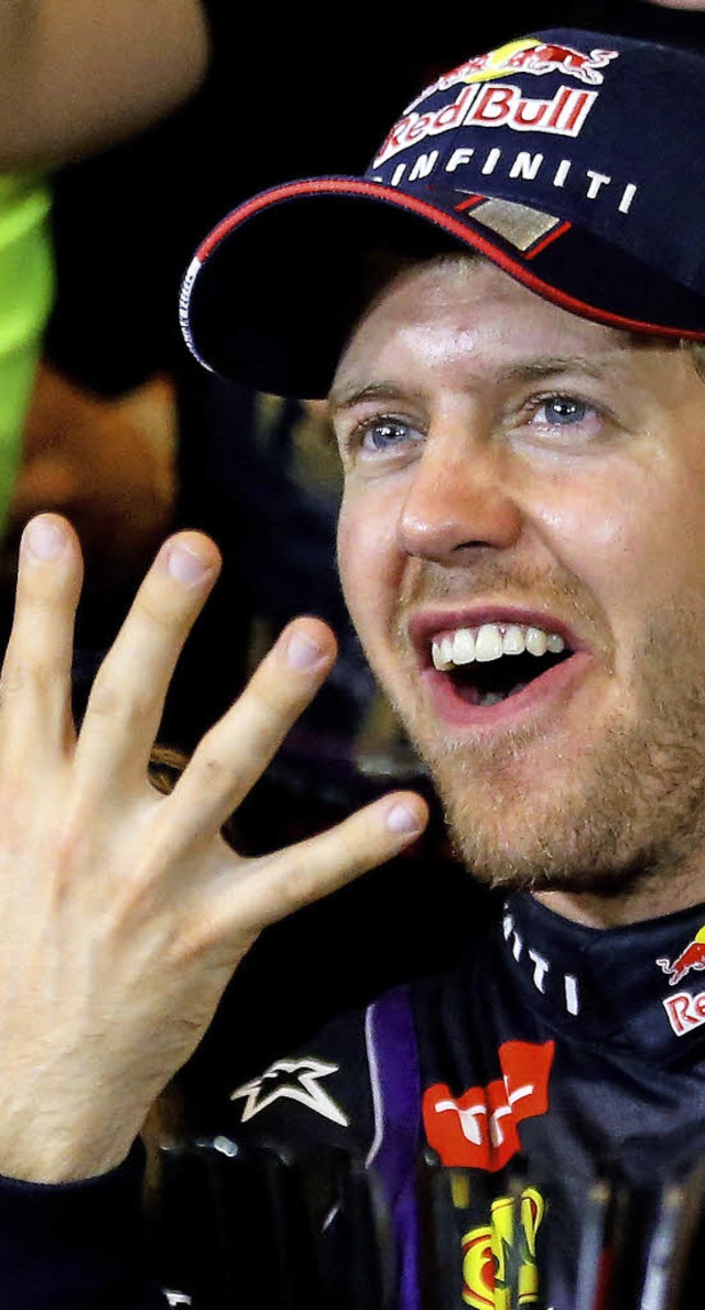 Das Zeichen des vierten Erfolgs: Sebastian Vettel  | Foto: DPA