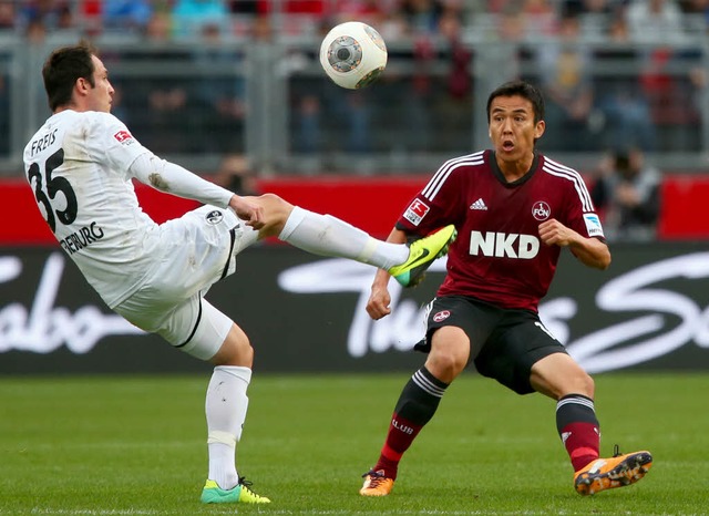 Der Nrnberger Makoto Hasebe (rechts) ...reiburger Sebastian Freis um den Ball.  | Foto: dpa